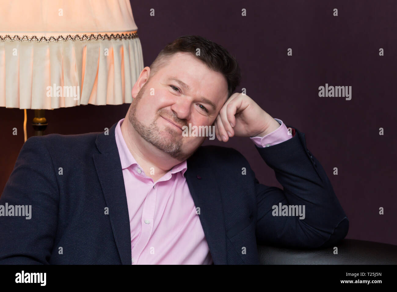 Solid Man Solid man with a beard in jacket sitting on the couch Stock Photo - Alamy