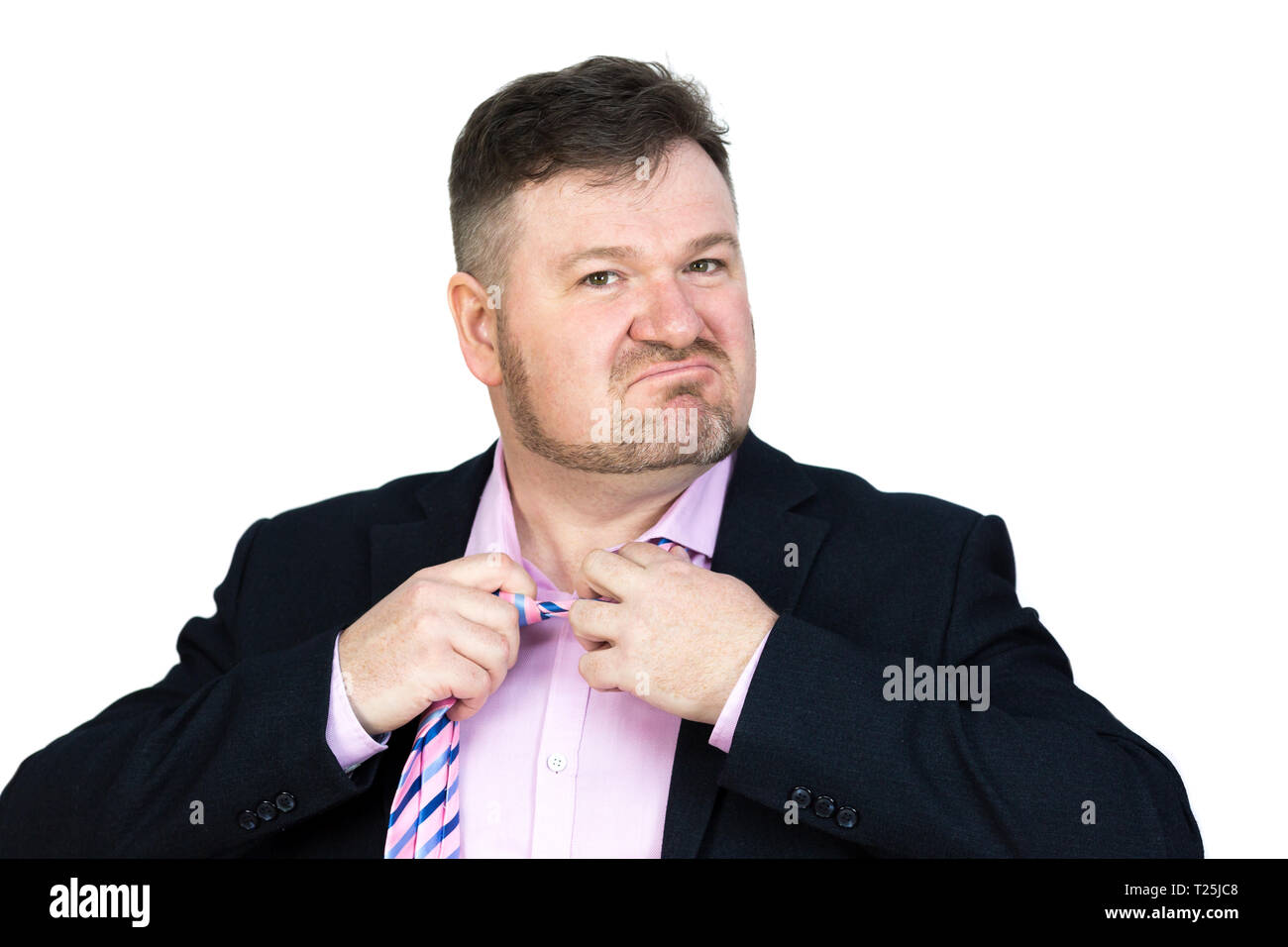 Angry fat man with  beard stretches removes his tie from his neck. Stock Photo