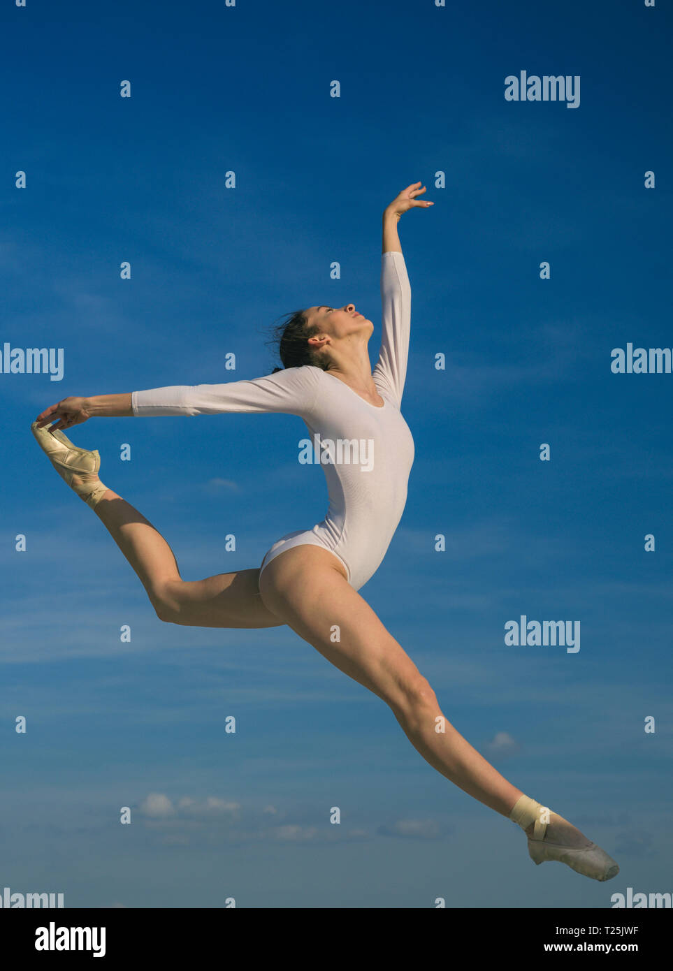 Graceful beauty. Concert performance dance. Young ballerina jumping on blue sky. Classic dance style. Cute ballet dancer. Pretty woman in dance wear Stock Photo