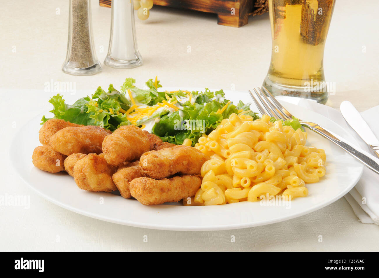 Chicken strips with macaroni and cheese and salad Stock Photo Alamy