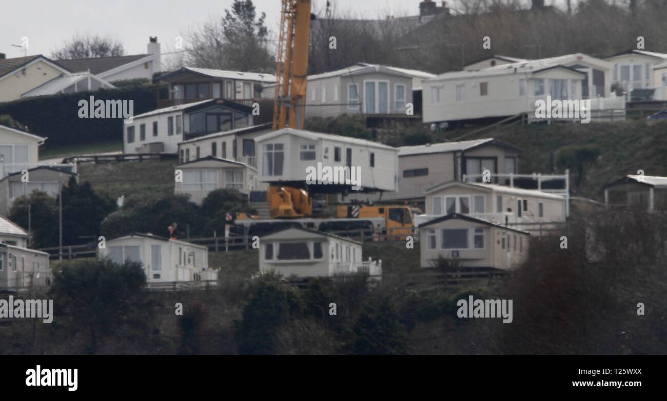 Prestatyn,uk A crane lifts a caravan into position on top of a mountain