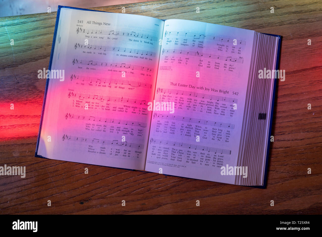 Light from stained glass window falls on open song book in american
