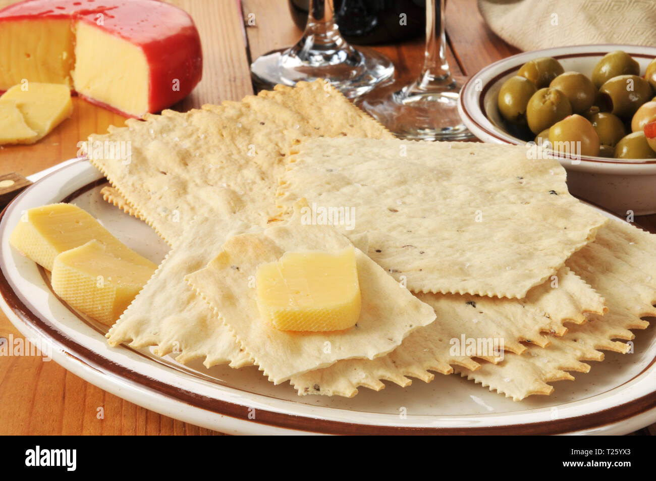 Gourmet flatbread crackers with gouda cheese, green olives and wine