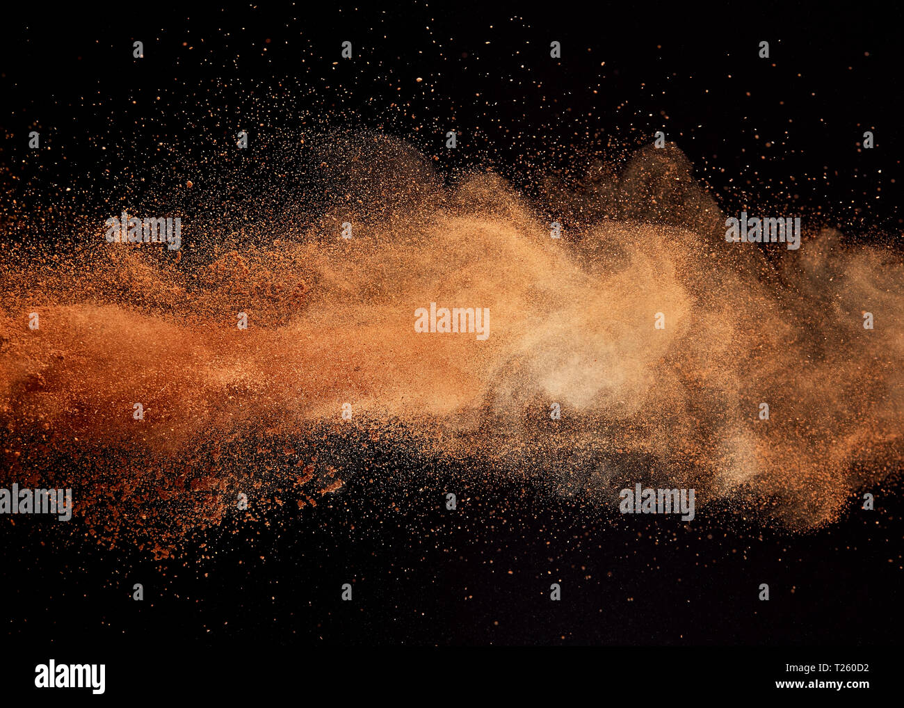 Cocoa powder explosion on black background Stock Photo Alamy