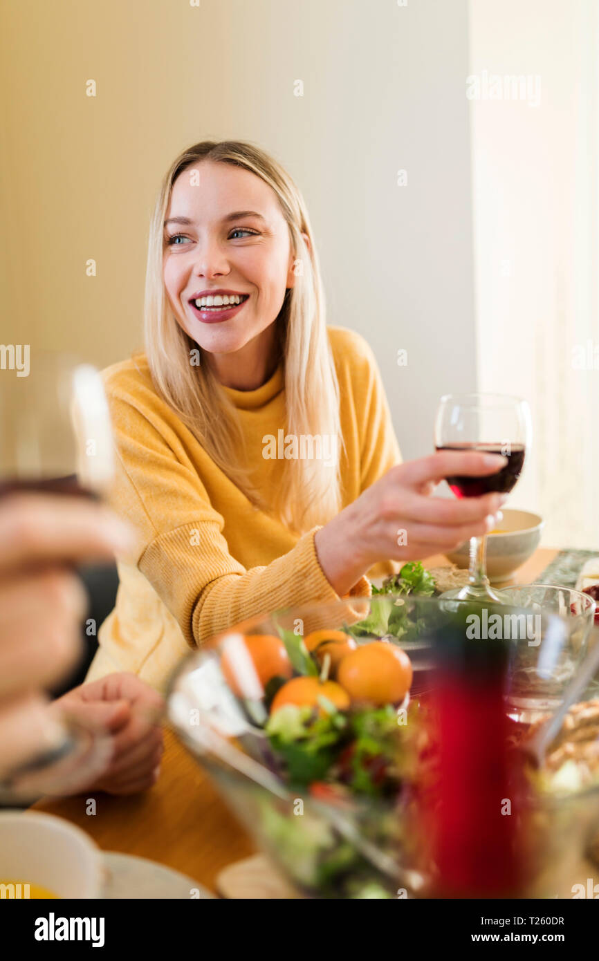Young woman drinking red wine ata lunch with friends Stock Photo