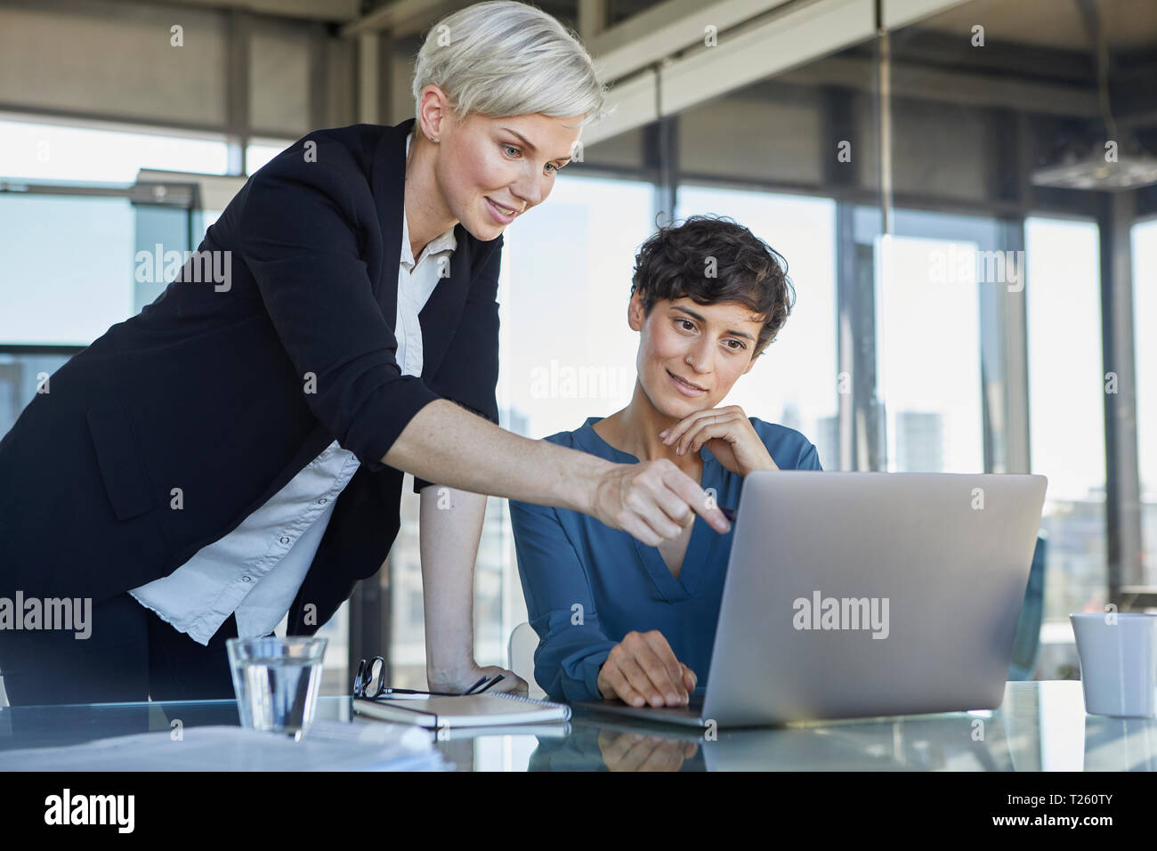 Businesswomen smiling at office desk hi-res stock photography and ...