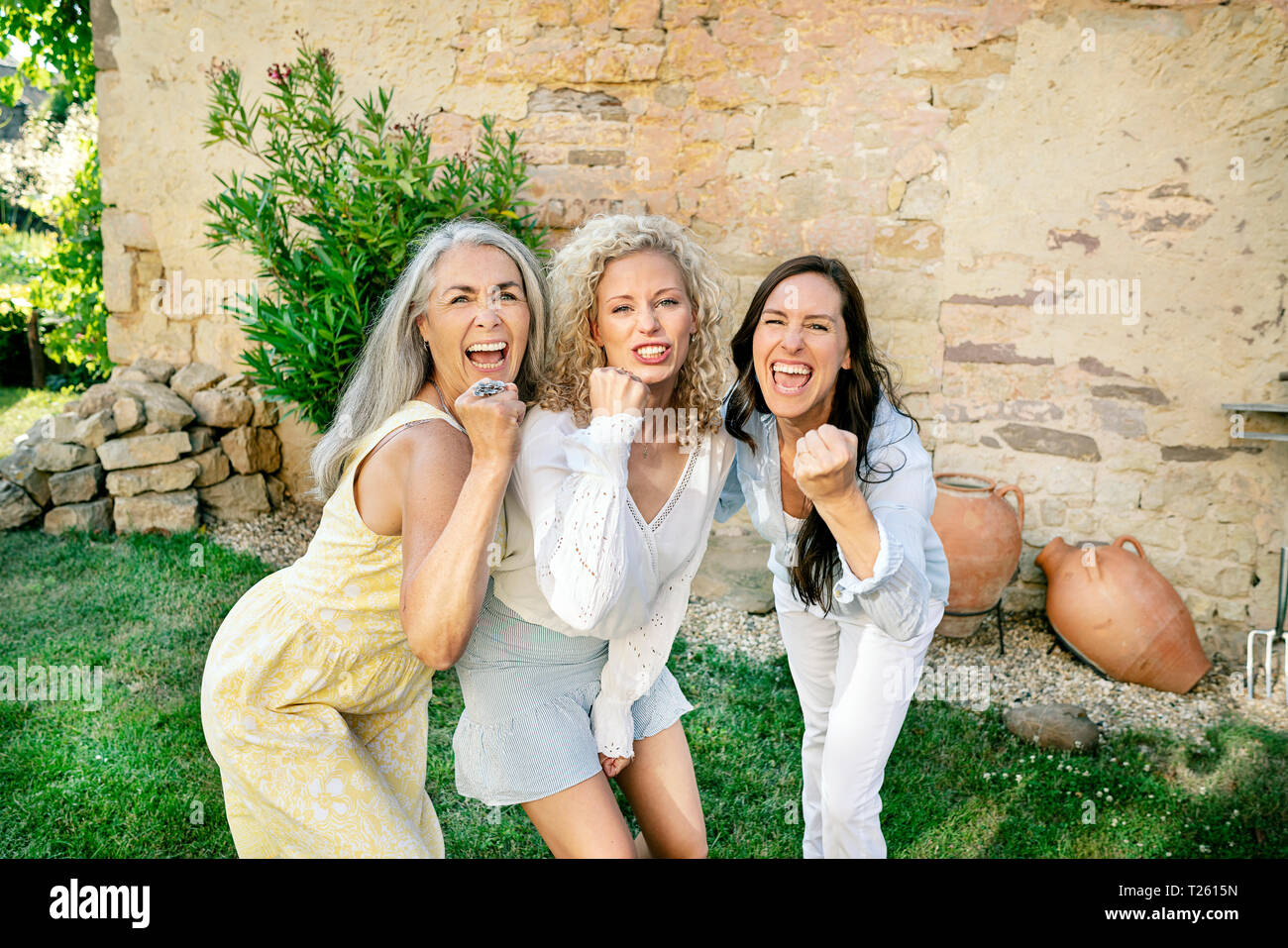 Portrait of three excited women of different age cheering Stock Photo