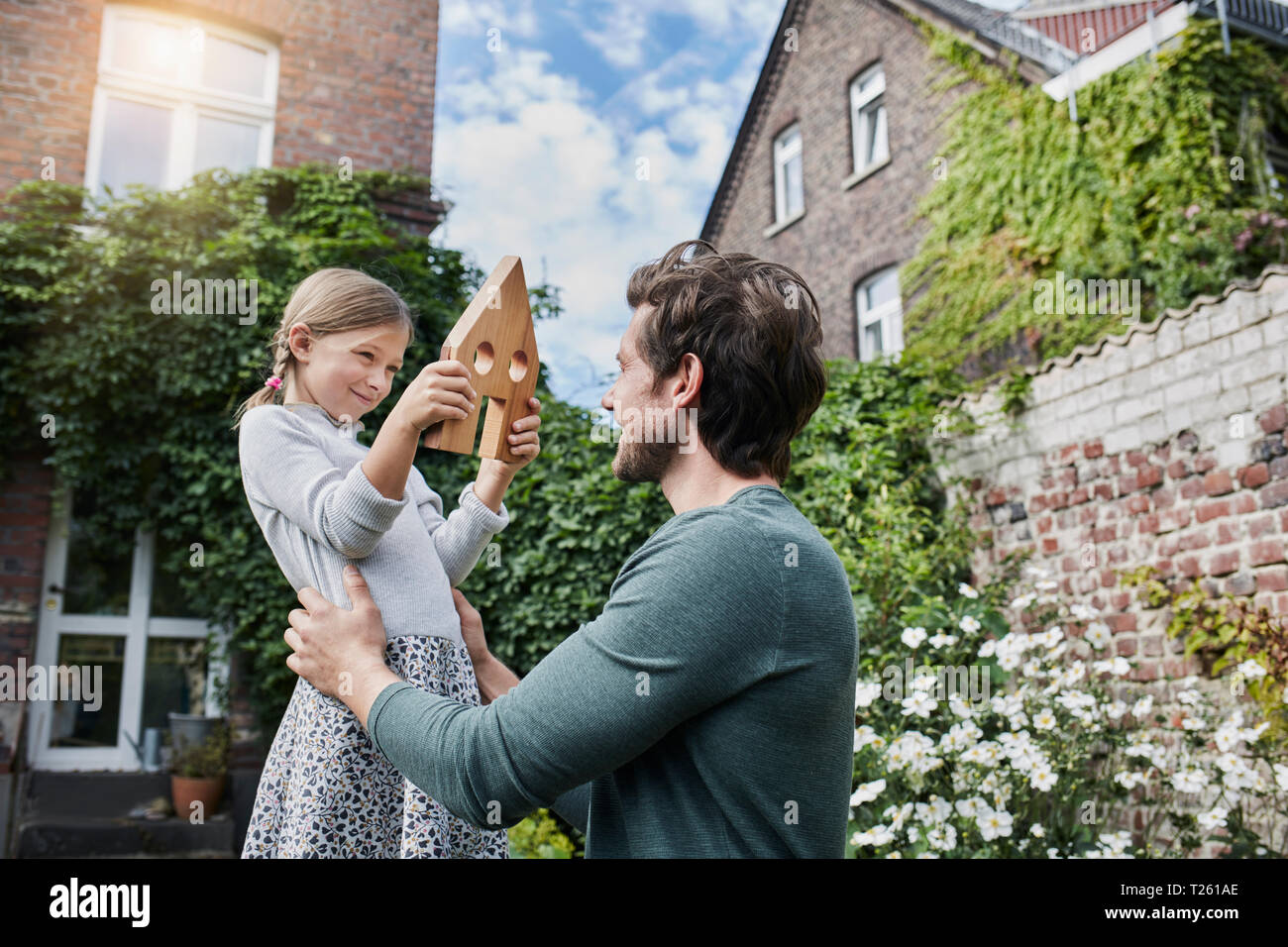 Father and daughter in garden of their home with house model Stock Photo