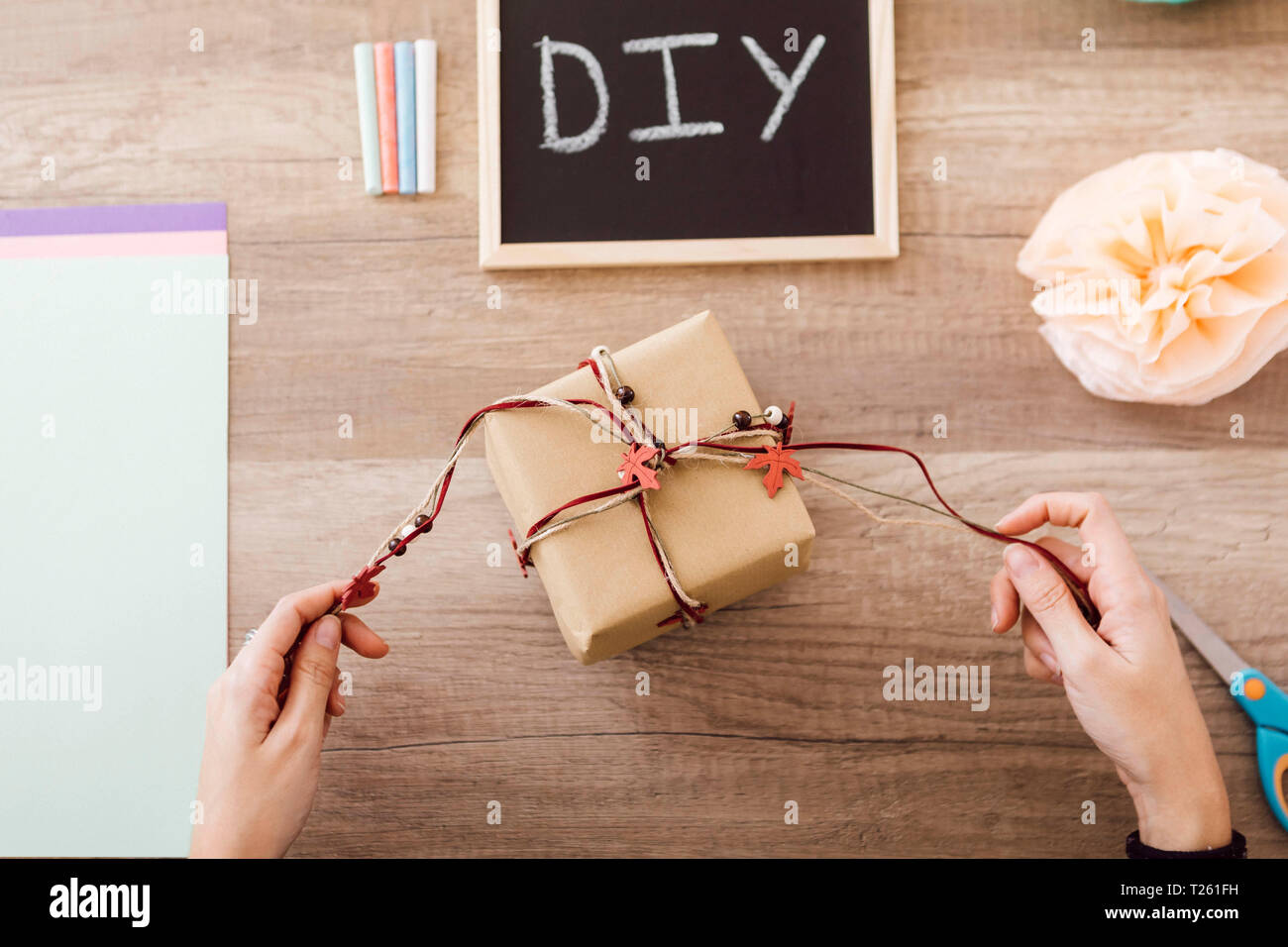 Top view of young woman wrapping a gift in her studio Stock Photo