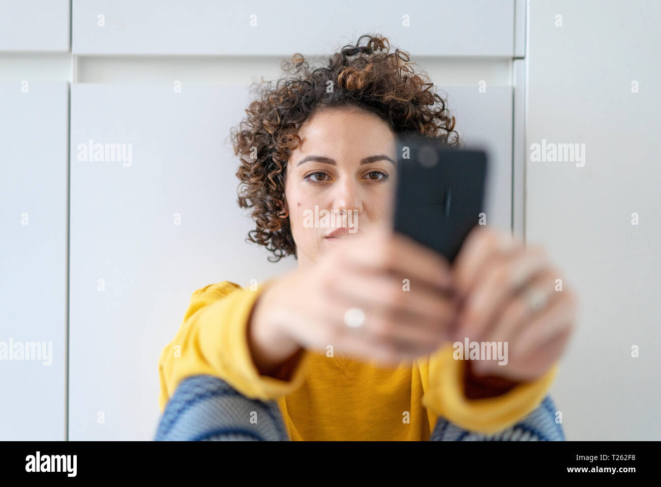 Woman using cell phone at home Stock Photo
