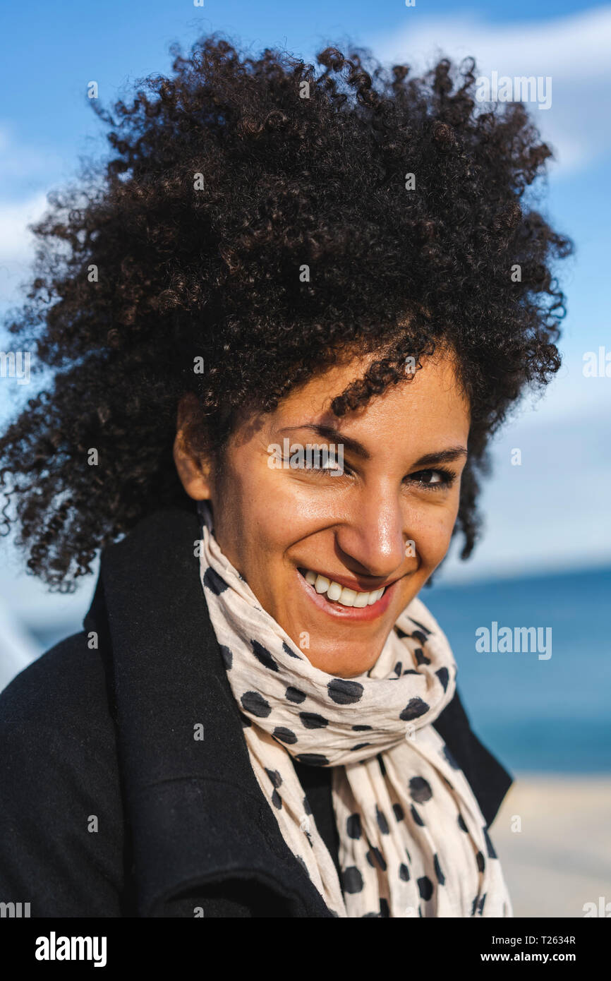 Portrait of smiling woman with curly hair Stock Photo