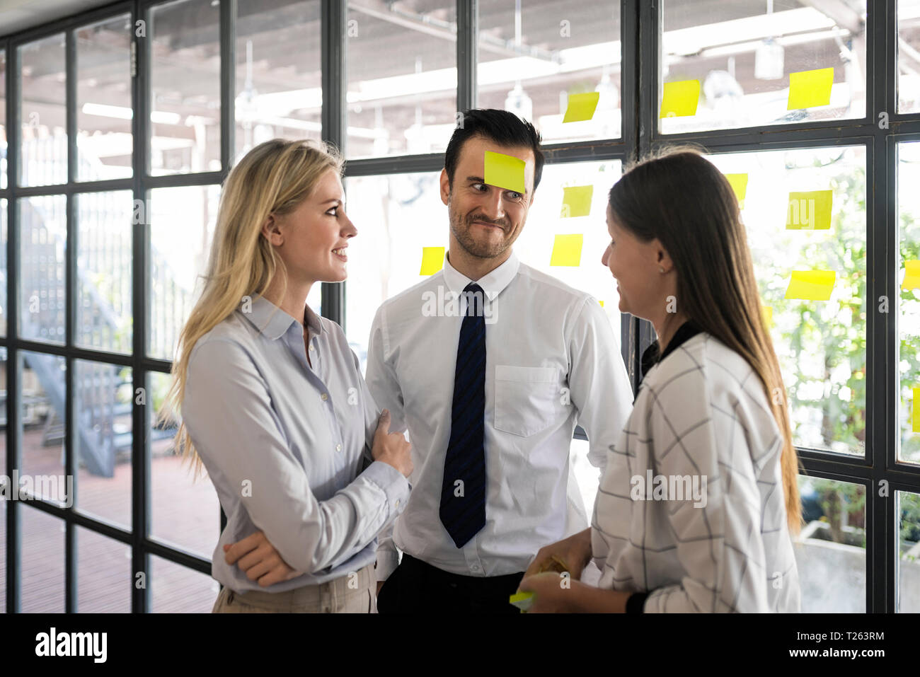 Colleagues in office brainstorming and fooling around with post-its Stock Photo