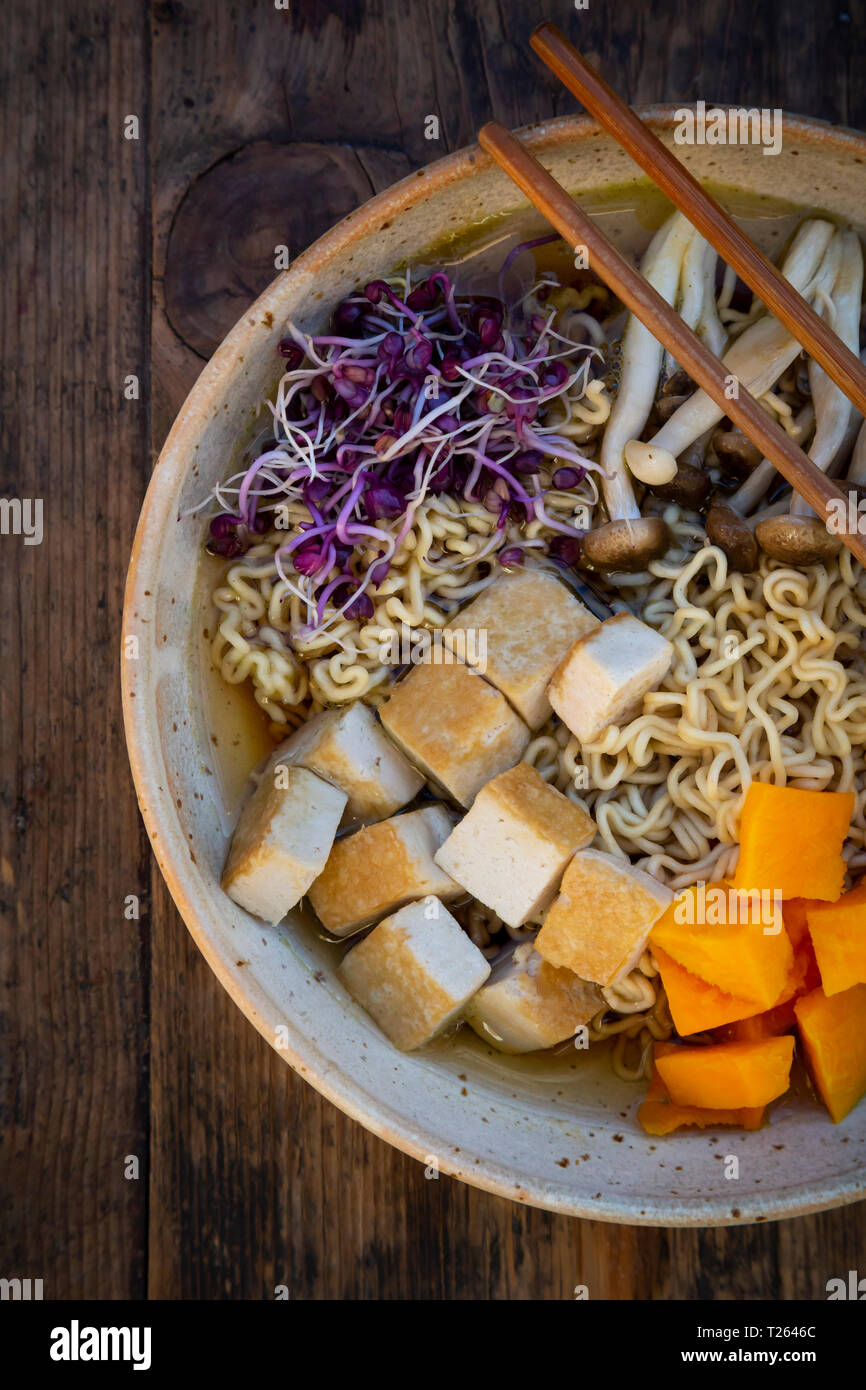 Miso Ramen soup with noodles, red radish sprouts, pumpkin, fried tofu, shimeji and king trumpet