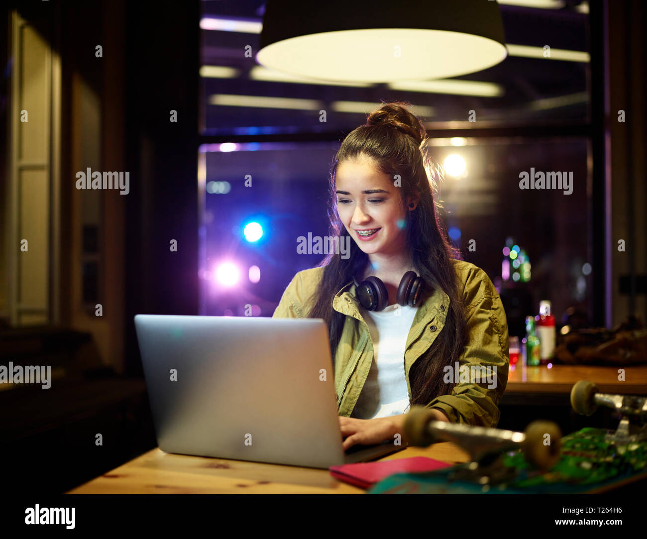 Smiling young woman using laptop on table Stock Photo