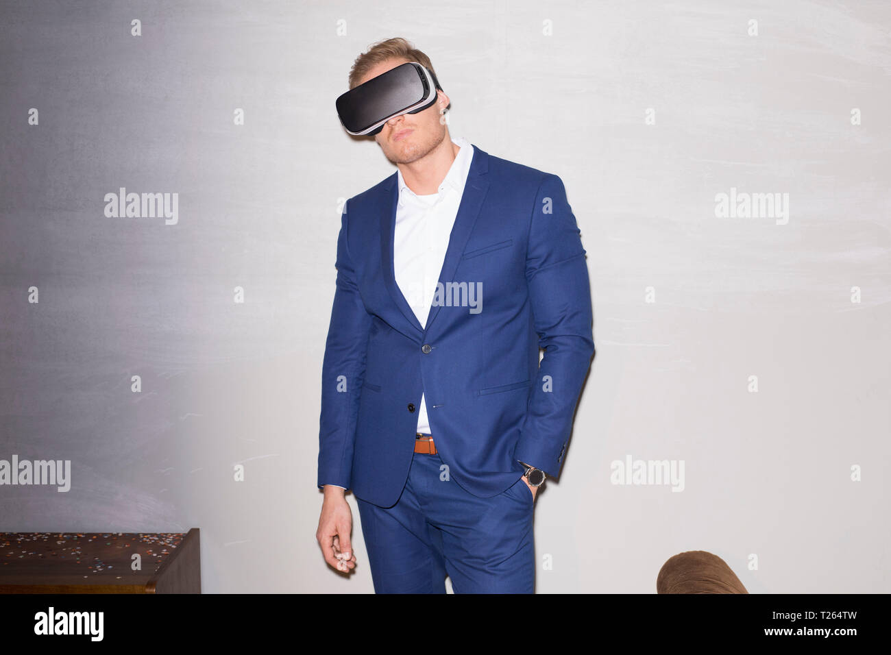 Young man wearing blue suit using Virtual Reality Glasses Stock Photo