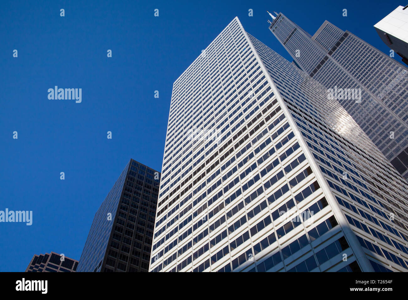 Looking up at business building in downtown, Chicago, USA. A view up through tall skyscrapers to a patch of blue sky Stock Photo