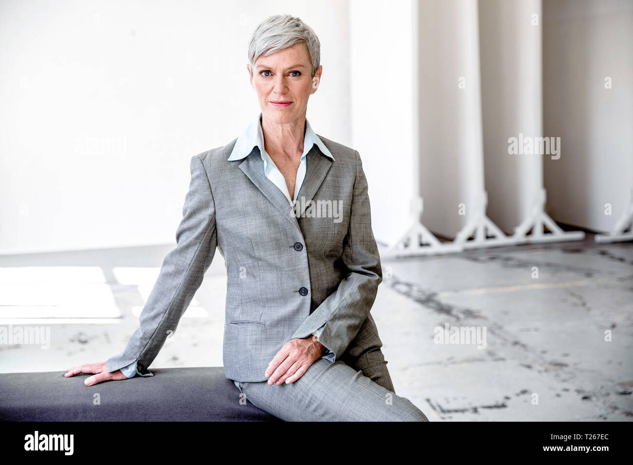 Portrait of mature businesswoman  wearing grey pantsuit Stock Photo