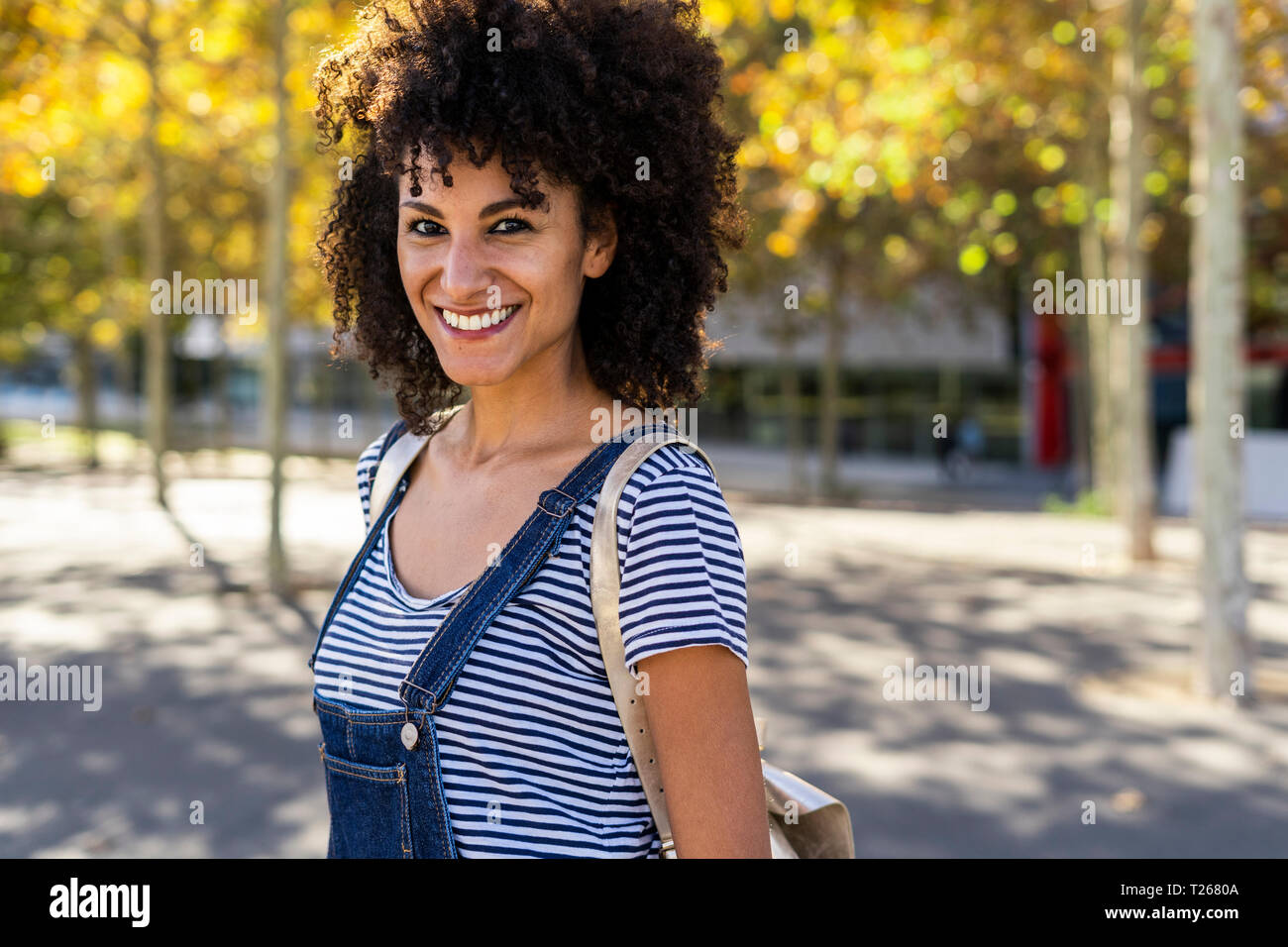 Portrait of a smiling woman, standing in a park Stock Photo - Alamy