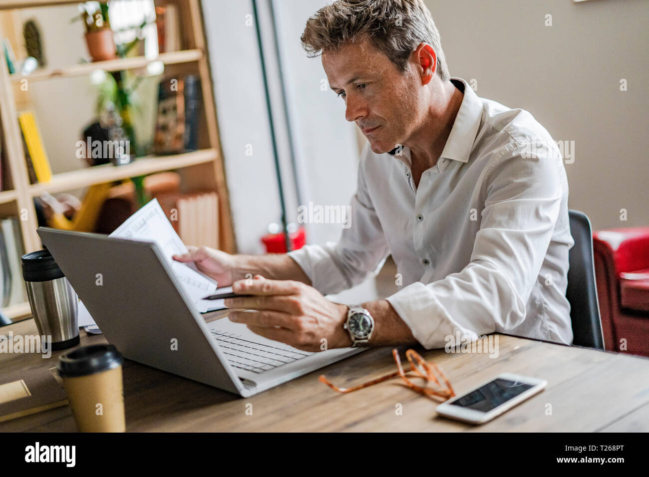Focused businessman using laptop at desk Stock Photo