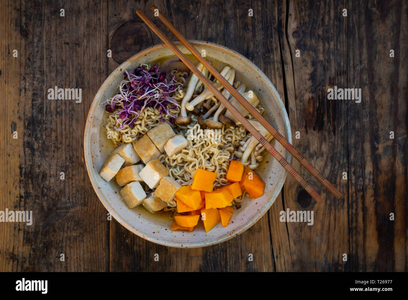 Miso Ramen soup with noodles, red radish sprouts, pumpkin, fried tofu, shimeji and king trumpet