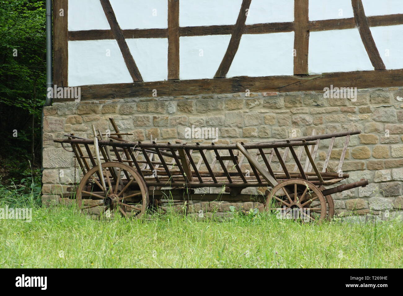 A historical cart parked before a half-timbered House Stock Photo
