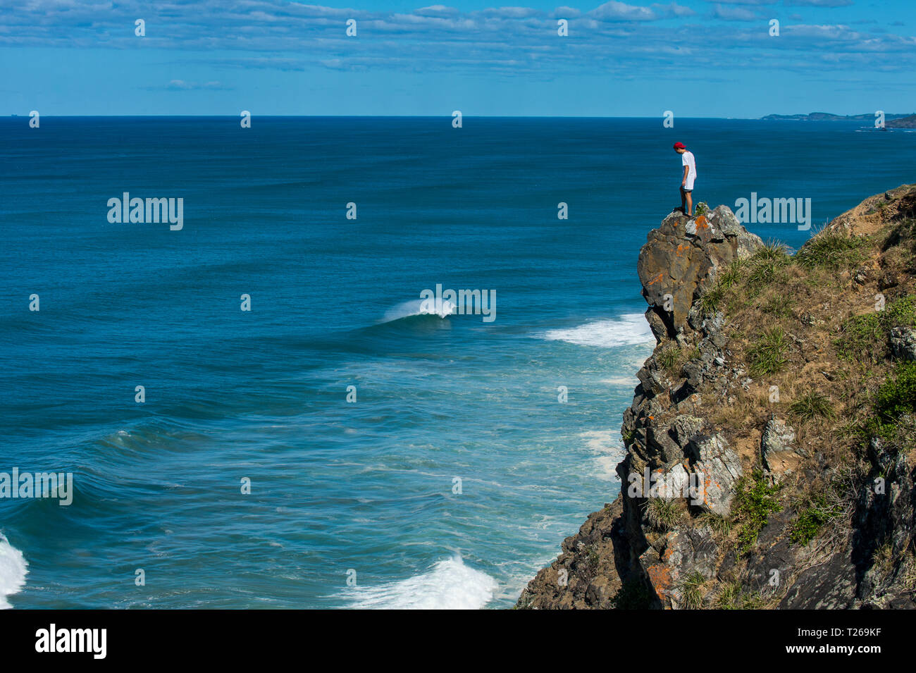 Australia, Queensland, Byron Bay, man standing on a rock, cliff at Cape Byron Stock Photo