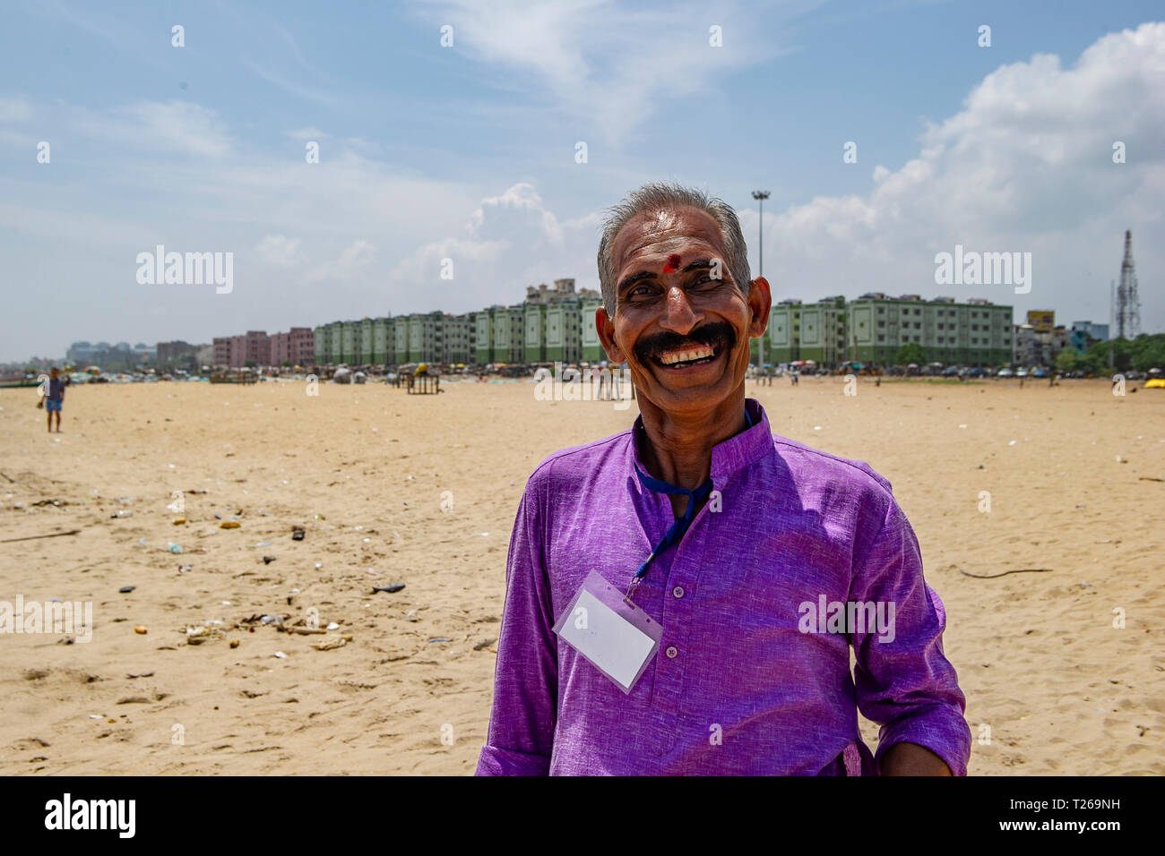 A moustached, smiling gentleman with a bindi enjoys the sea at Marina Beach, with the Bay of Bengal in Chennai, India Stock Photo