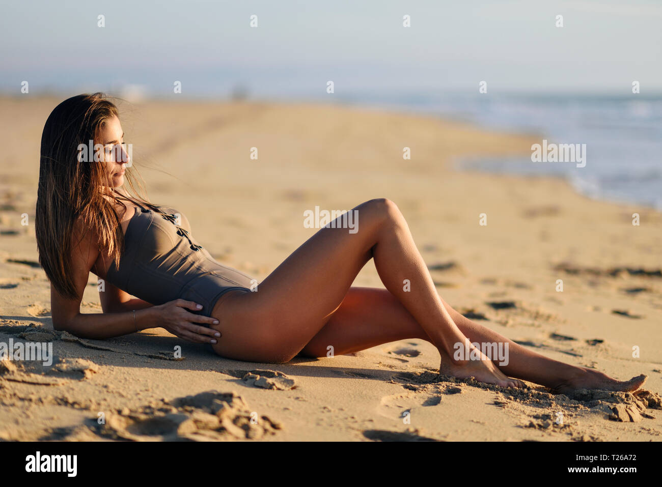 Beautiful woman wearing swimsuit lying on the beach Stock Photo