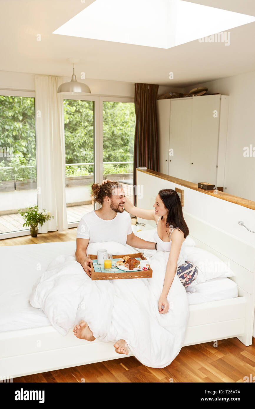 Affectionate couple having breakfast in bed Stock Photo