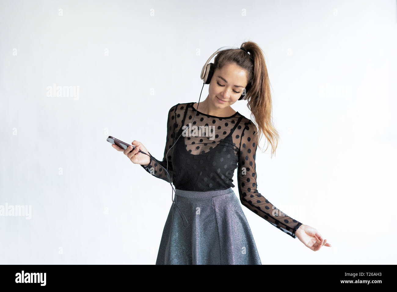 Young, elegant woman, listening music, using smartphone Stock Photo