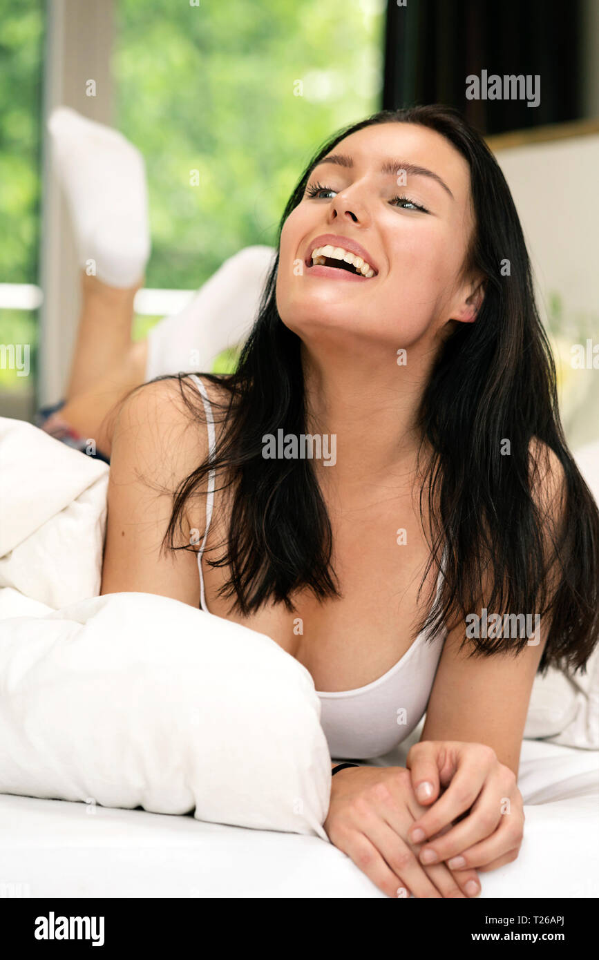 Beautiful woman lying on bed, smiling, portarit Stock Photo