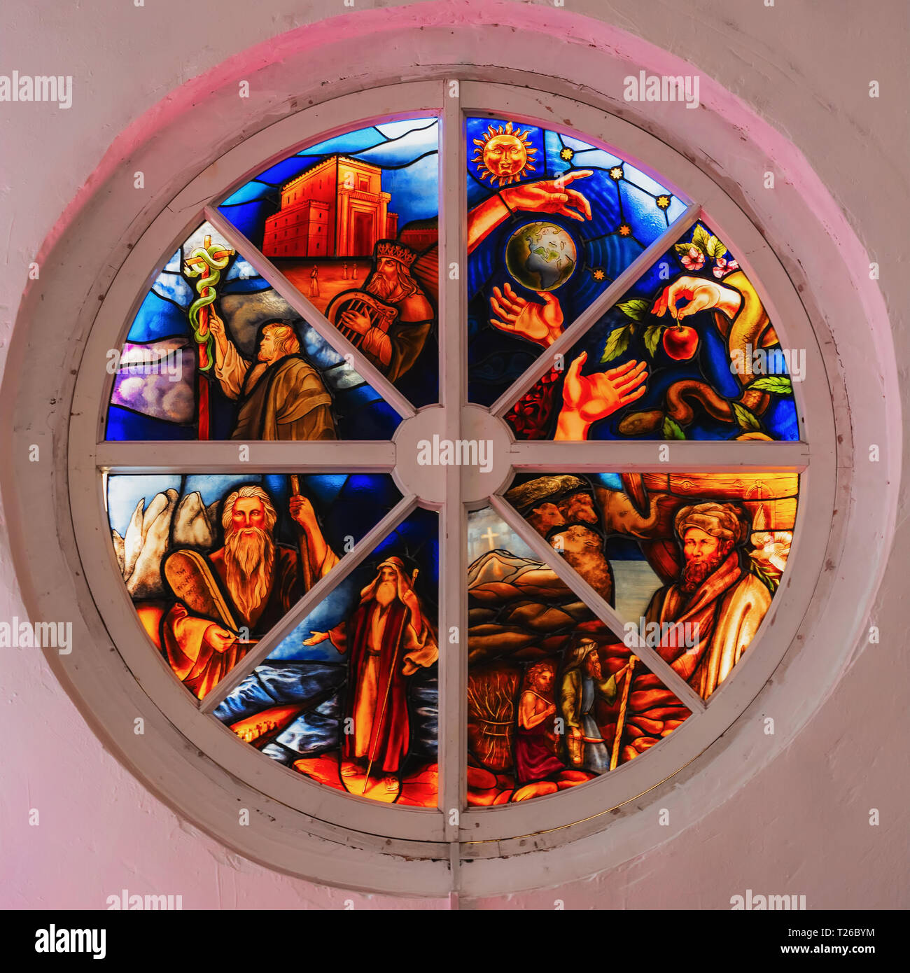 Old round stained glass window in a destroyed in the church, bright