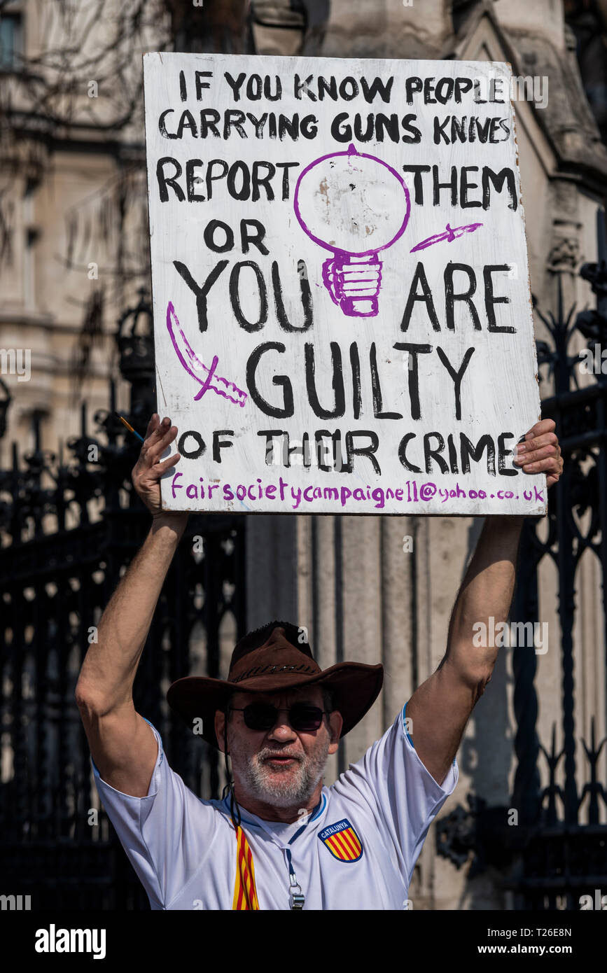 Knife and gun crime protest placard. Protester. If you know people carrying guns or knives report them or you are guilty of their crime. Complicit Stock Photo