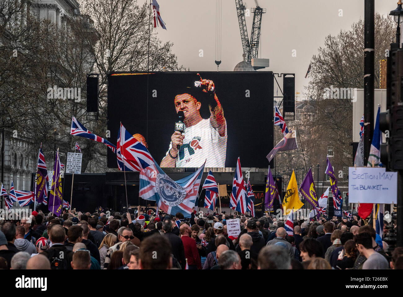 tommy-robinson-speaking-on-stage-at-the-brexit-betrayal-protest-rally-in-whitehall-westminster-london-uk-with-crowd-and-union-jack-flags-T26EBX.jpg