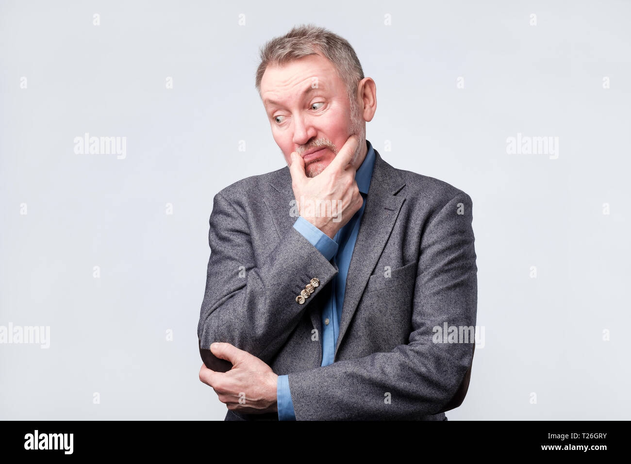 Handsome middle age man in suit has doubt expression, is confused, uncertain in future Stock Photo