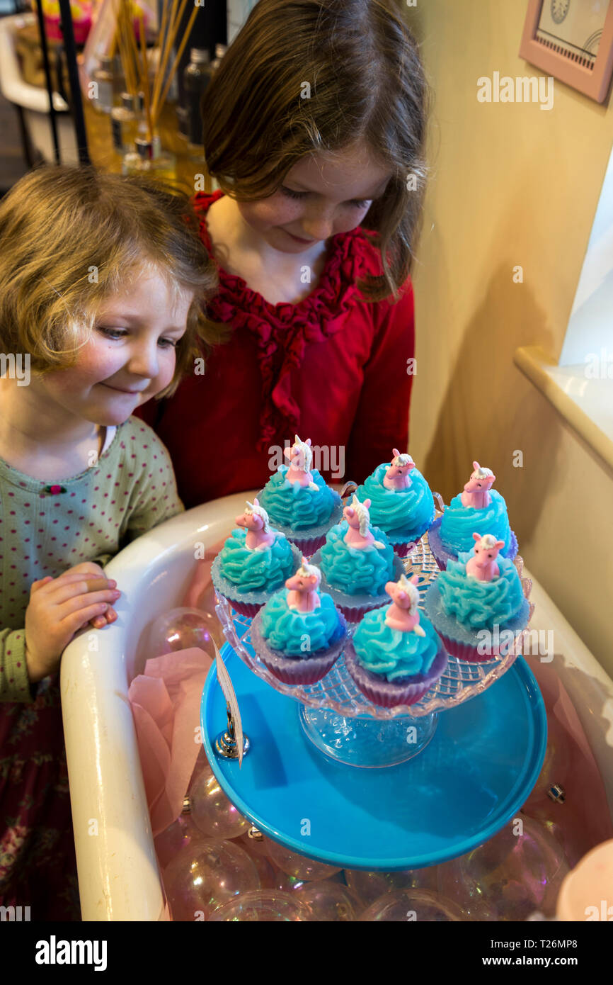 Children aged four and six / kid / kids / children / girls / girl examine and smell the Unicorn