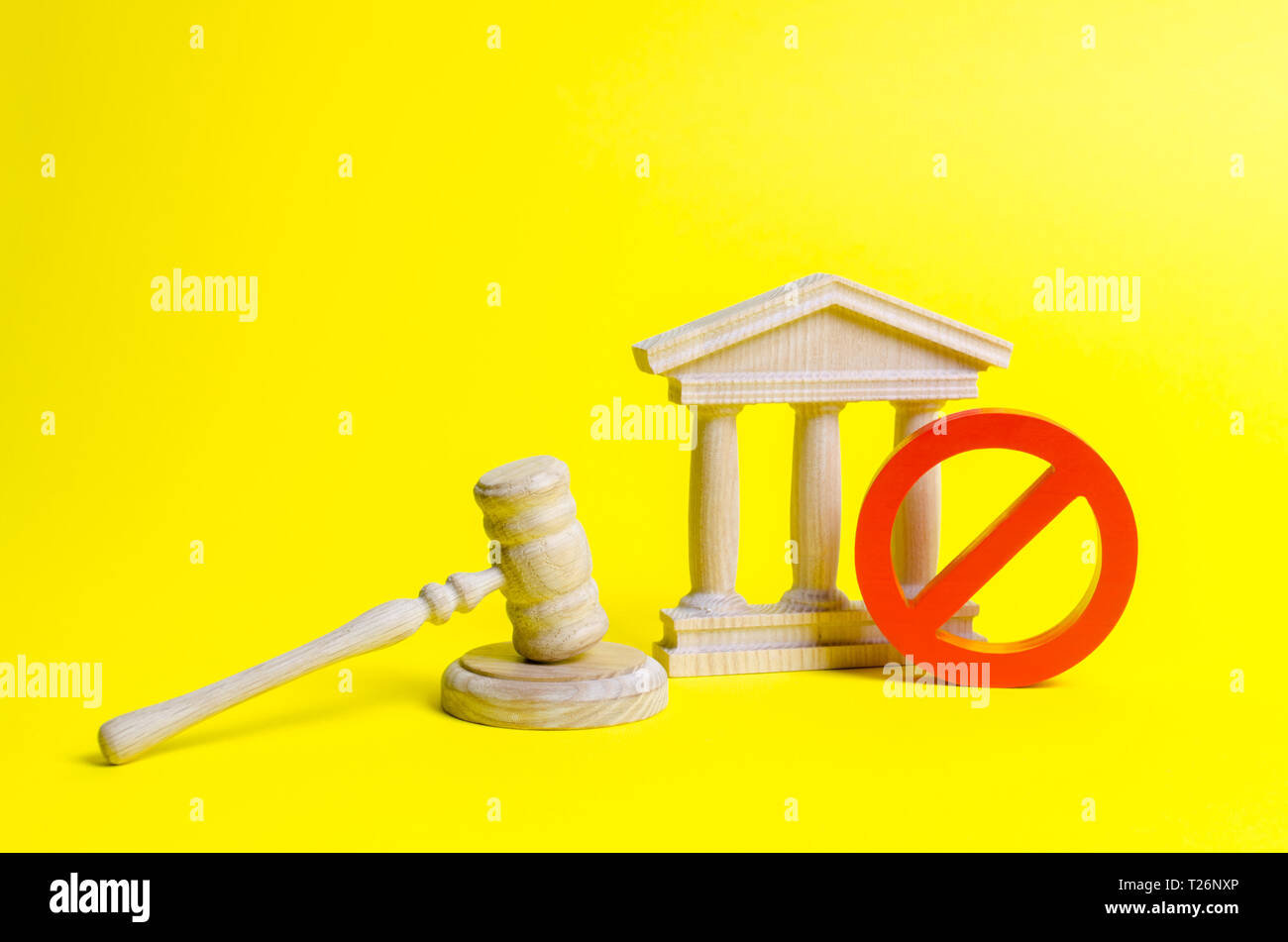 Wooden judge hammer and government building on a yellow background