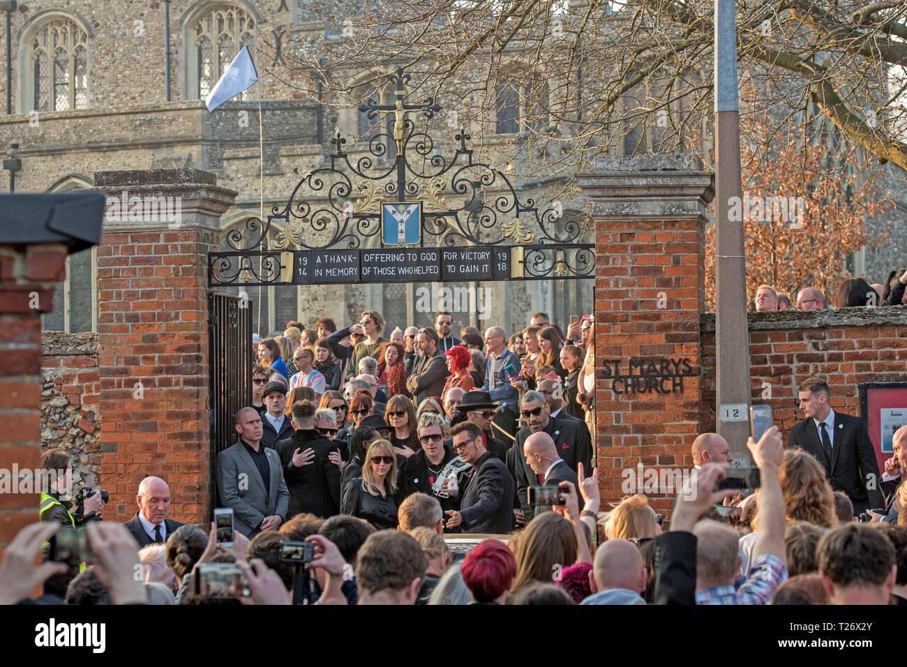 Essex, UK. 30th March 2019. The  funeral of Prodigy singer Keith Flint at St Marys Church in Bocking,  Essex today. Mourners leave the service and band members Liam Howlett, Maxim (Keith Palmer) and Leeroy Thornhill can be seen leaving the front gates of the church. Credit: Phil Rees/Alamy Live News Stock Photo