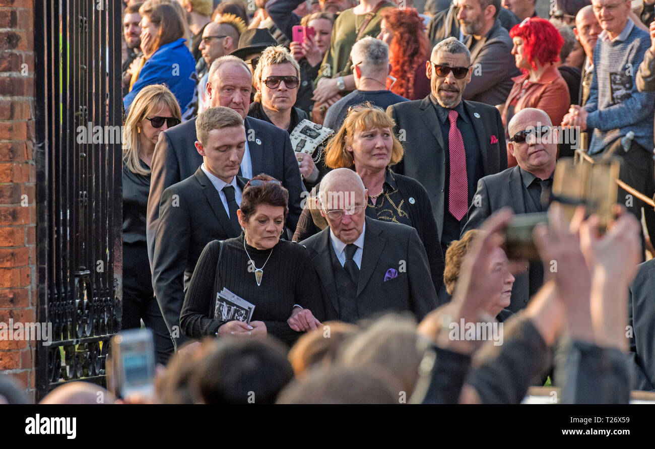 Essex, UK. 30th March 2019. The  funeral of Prodigy singer Keith Flint at St Marys Church in Bocking,  Essex today. Mourners leave the service and band members Liam Howlett and Leeroy Thornhill can be seen following Keith’s father Clive Flint out of the front gates of the church. Credit: Phil Rees/Alamy Live News Stock Photo