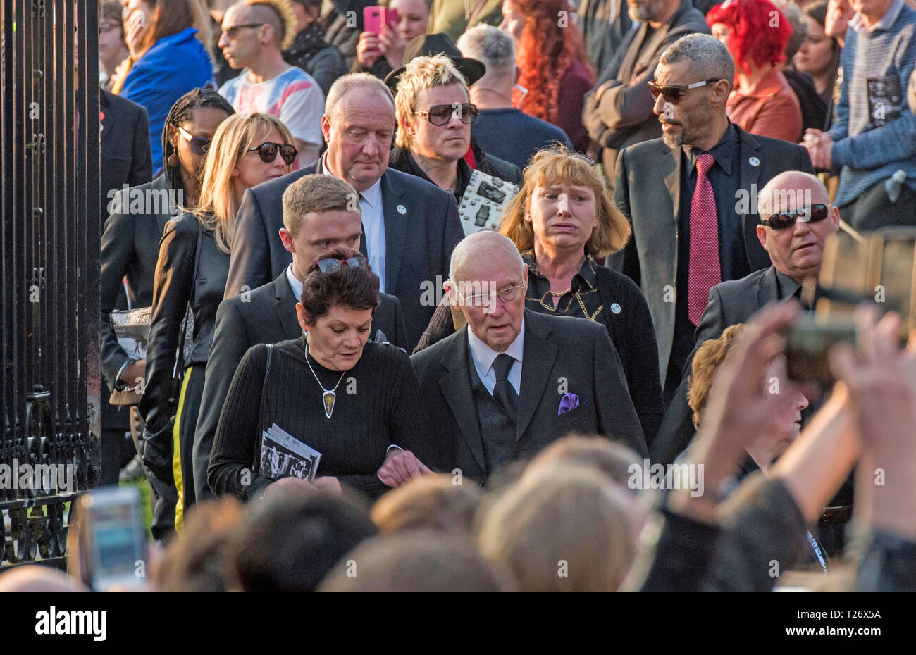 Essex, UK. 30th March 2019. The  funeral of Prodigy singer Keith Flint at St Marys Church in Bocking,  Essex today. Mourners leave the service and band members Liam Howlett, Maxim (Keith Palmer) and Leeroy Thornhill can be seen following Keith’s father Clive Flint out of the front gates of the church. Credit: Phil Rees/Alamy Live News Stock Photo