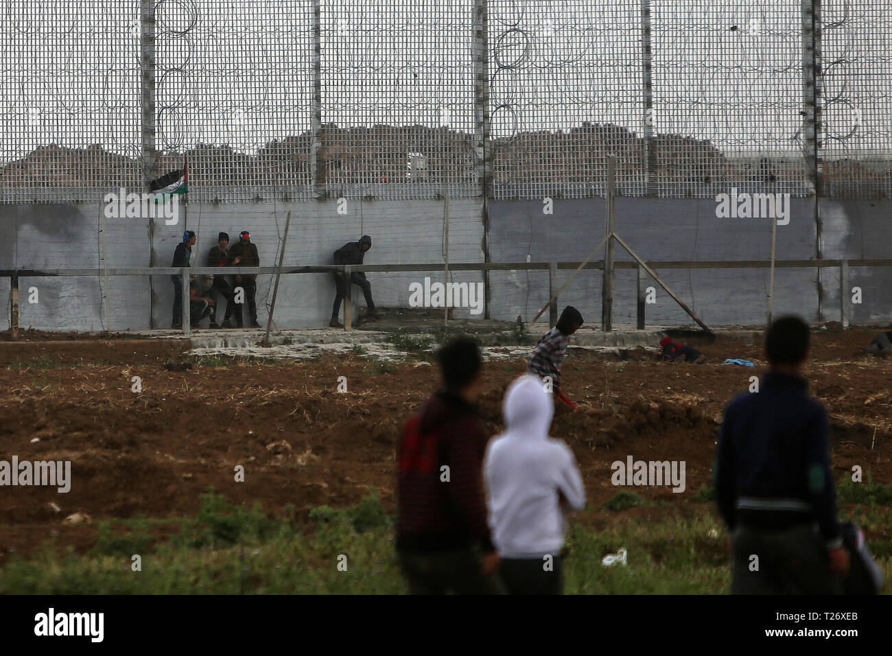 Gaza. 30th Mar, 2019. Palestinian protesters clash with Israeli troops on the Gaza-Israel border, east of Gaza City, March 30, 2019. Thousands of Palestinians marked on Saturday the Palestinian Land Day and the first anniversary of the Palestinian Great March of Return. Credit: Stringer/Xinhua/Alamy Live News Stock Photo