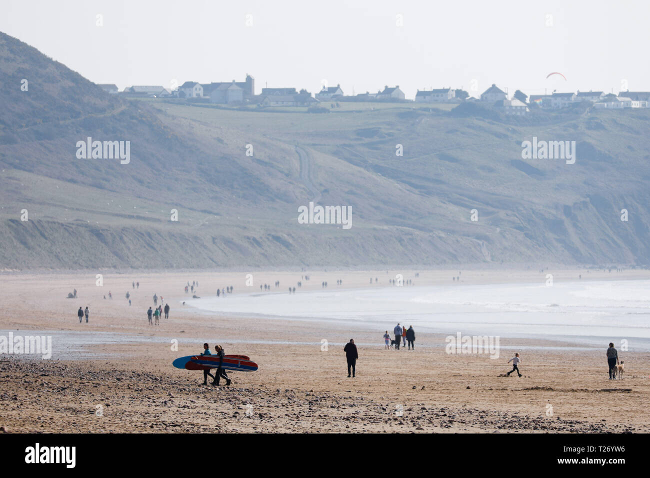 Swansea, 30th March, 2019. UK Weather.  Great Escape: sun seekers made a beeline for the seaside on the Gower peninsula, near Swansea, this weekend.  Long periods of hazy sunshine brought some warmth to the sands at Llangennith beach in Rhossili Bay but a cool north westerly breeze meant that most day trippers kept their coats on. Credit: Gareth Llewelyn/Alamy Live News. Stock Photo