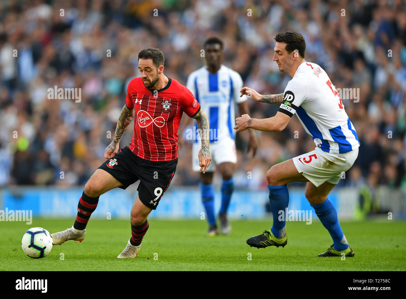 Brighton, UK. 30th March 2019.  Southampton forward Danny Ings gets away from Brighton defender Lewis Dunk during the Premier League match between Brighton and Hove Albion and Southampton  Editorial use only, license required for commercial use. No use in betting, games or a single club/league/player publications. Photograph may only be used for newspaper and/or magazine editorial purposes. May not be used for publications involving 1 player, 1 club or 1 competition without Credit: MI News & Sport /Alamy Live News Stock Photo