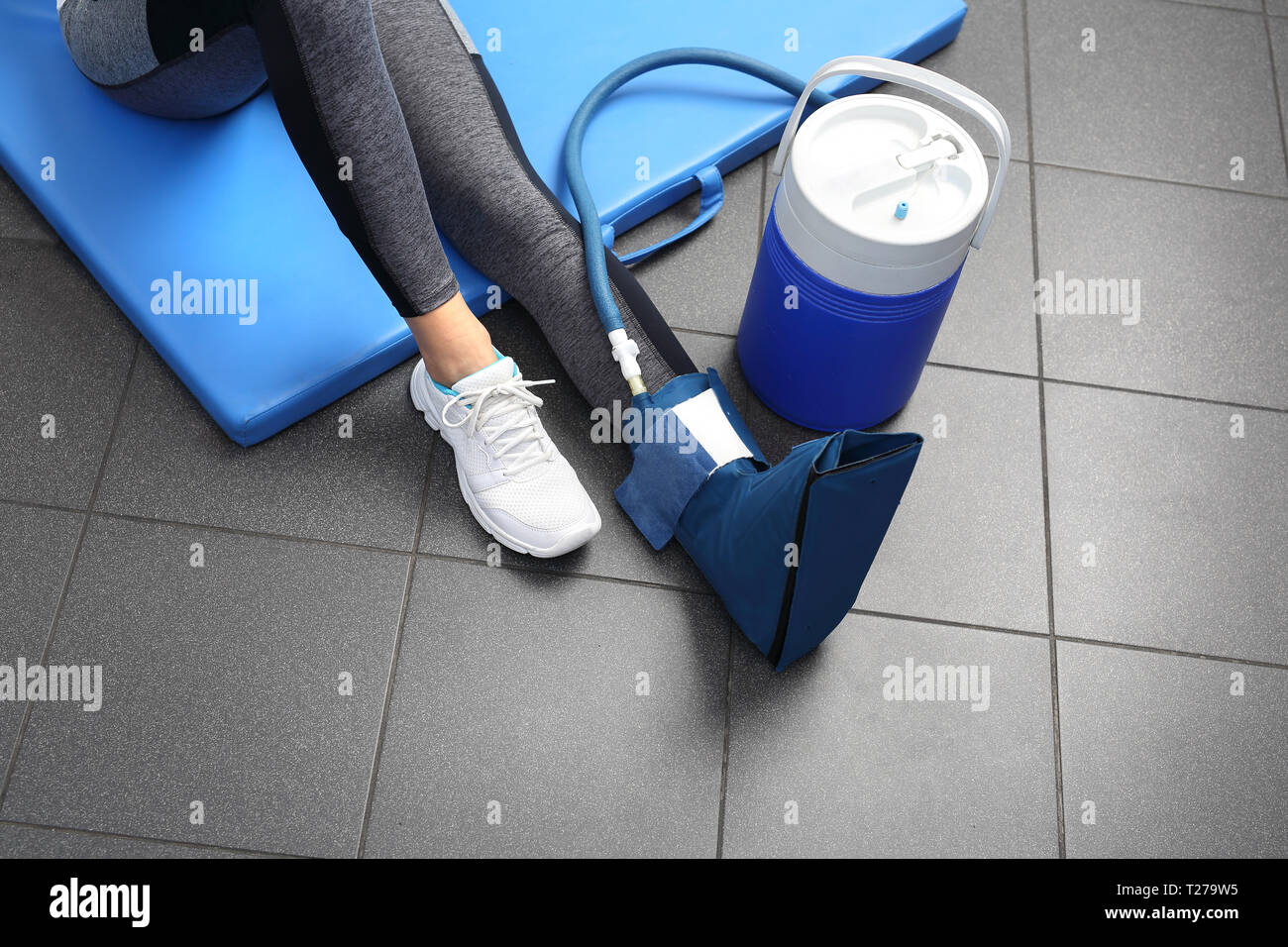Cold treatment. A woman with a cooled input on the leg. Stock Photo