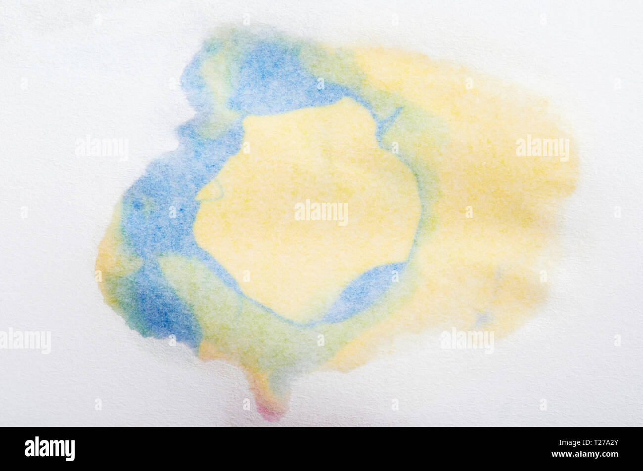 Blue and yellow abstract paint splash on paper close up view Stock Photo