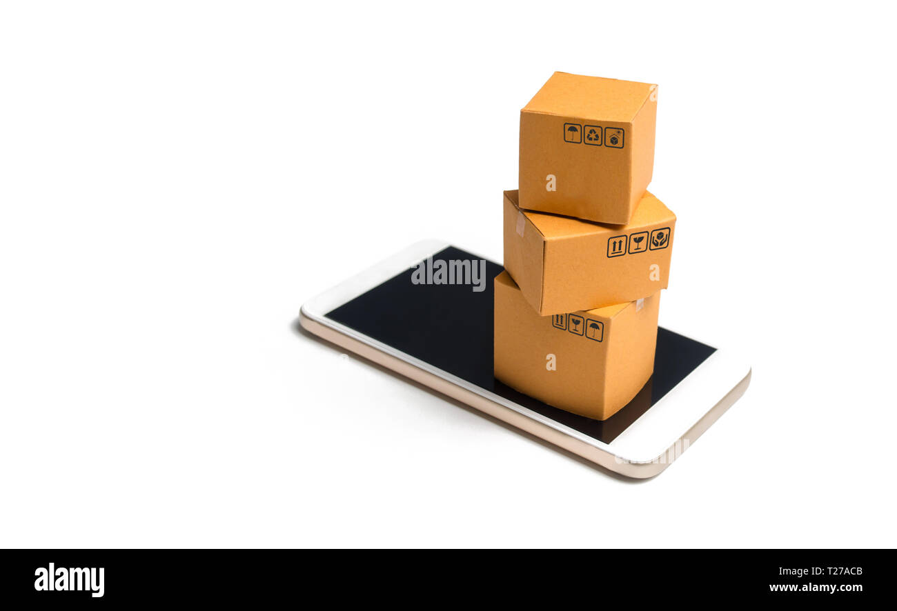 A stack of boxes on a smartphone. Online shopping concept. Shopping through the mobile app. Goods and services, e-commerce. Online retail. Marketing.  Stock Photo