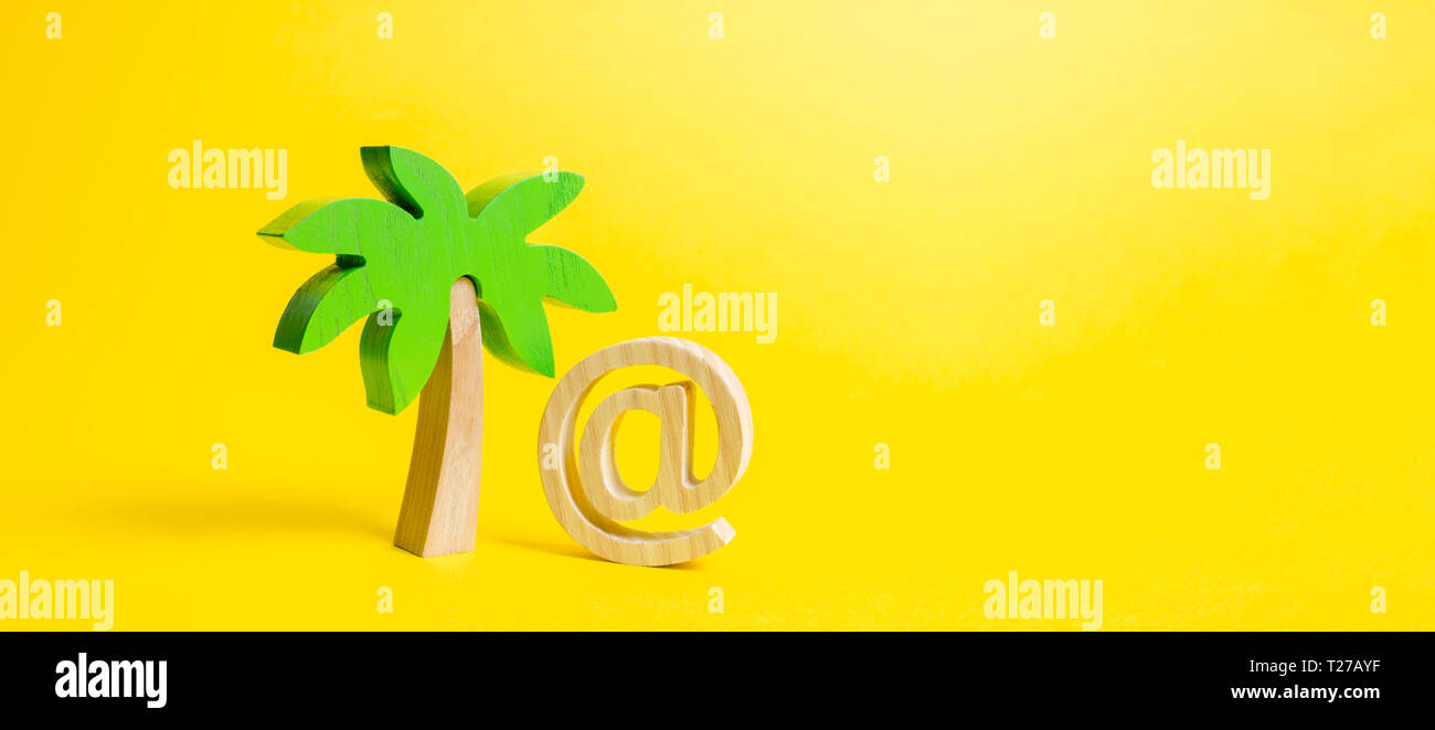 Palm figurine and symbol of internet or email. Remote work, part-time job. Outsourcing services. Work during vacation or travel, business trip. Busine Stock Photo