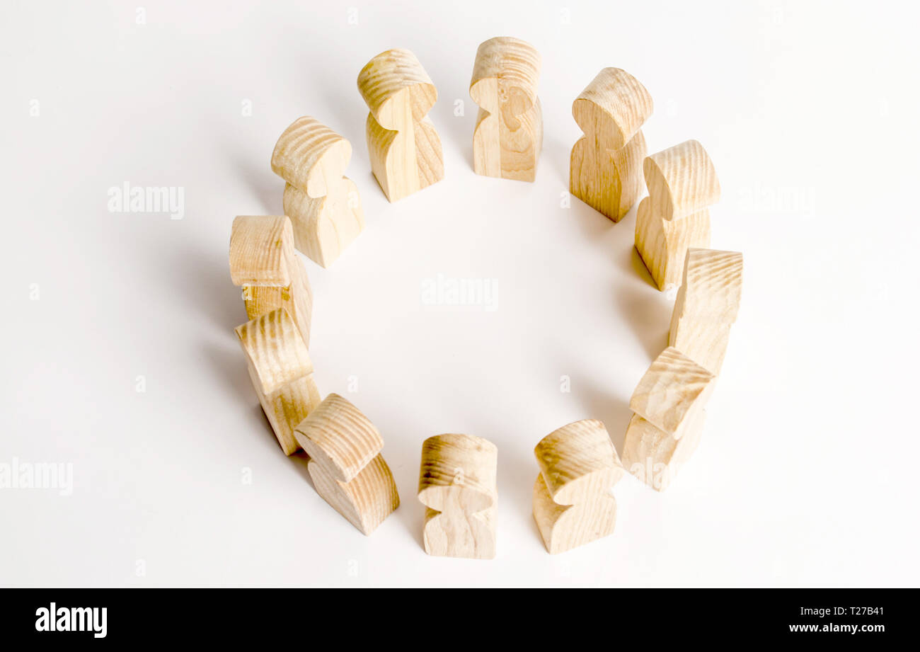 People stand in a circle on a white background. Wooden figures of people. A circle of people. discussion and cooperation, coordination cooperation. Co Stock Photo