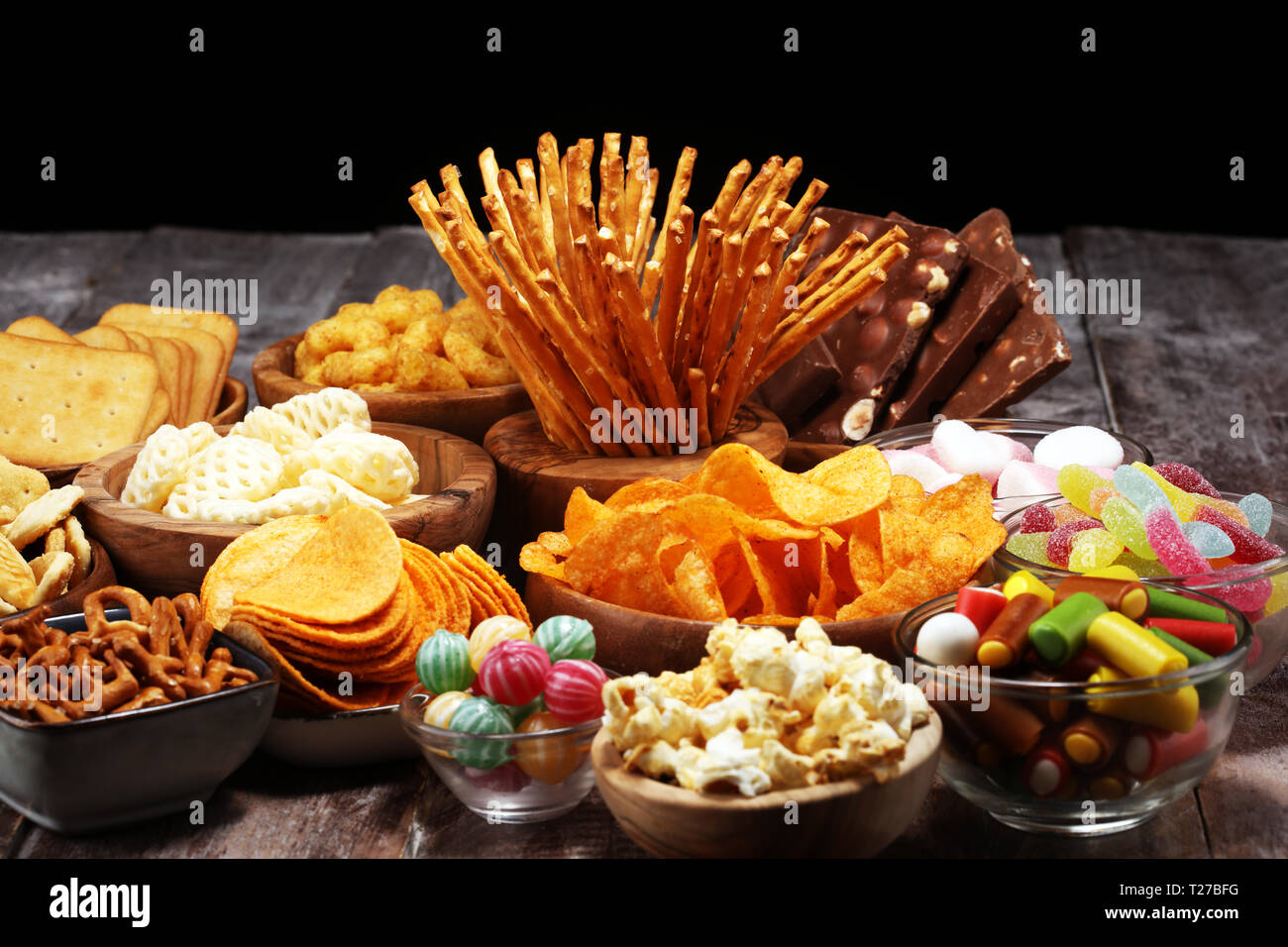 Salty snacks. Pretzels, chips, crackers in wooden bowls. Unhealthy