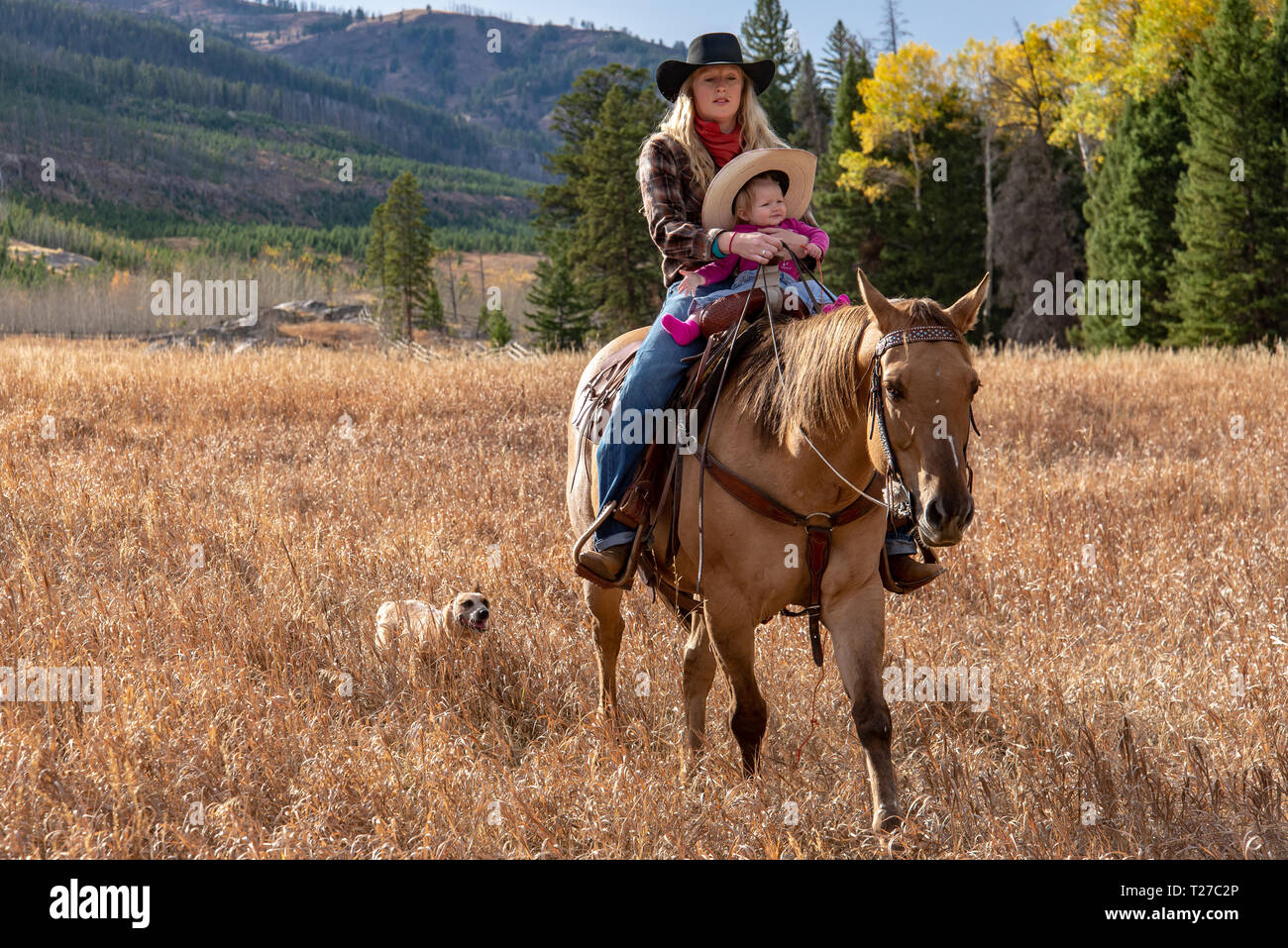 Cowgirl and baby on horseback in Wyoming, USA Stock Photo